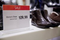 Close-up of a price tag next to a pair of shoes.