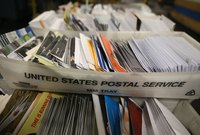 Boxes of mail sit on a cart at a US Post Office