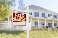 A house with a "sold" sign in front.