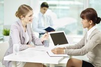Young businesswoman speaking with human resources employee