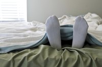 Feet wearing socks sticking out from the covers.