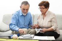 An elderly couple looking at bank statements