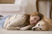 Woman laying on floor beside her dog.