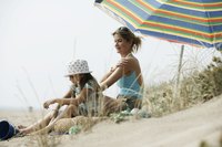 A mother is applying sunscreen to her child.