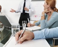 Executives take notes during a strategy meeting.