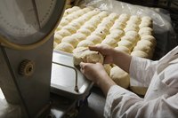 A baker weighs balls of dough.