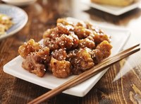 A place of sesame chicken with chopsticks.