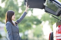 A business woman loading boxes into her vehicle.