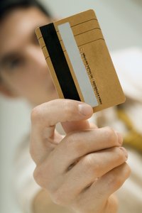 A man is holding a debt card upright.