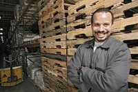 A view of a happy worker standing in a warehouse.