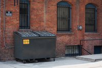 Dumpster against a brick building.