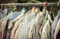 Clothes on a rack at a thrift store.