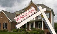 A house with a foreclosure sign in front.