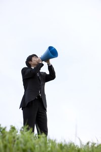 Grip the megaphone around the mouth section and talk into it to amplify your voice.