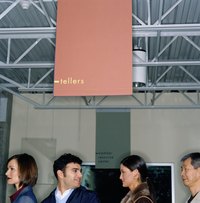 People are waiting in line for a bank teller.
