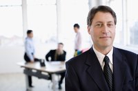 A business man is standing in front of his colleagues.