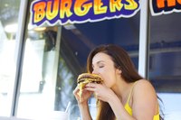 Woman eating a hamburger at a fast food restaurant.