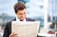 Young man reads morning newspaper