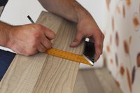 Man measuring and marking laminate floor