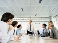 A CEO addresses co-workers in a board meeting
