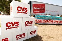 CVS pharmacy boxes stacked in the foreground with a CVS extra care truck in the background
