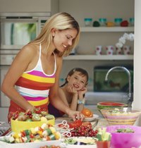 Pretty woman and young lady preparing kabobs for baking.