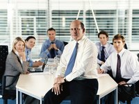 A CEO sitting with his employees in a conference room