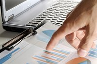 Hand pointing at business charts.