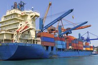 A cargo ship with shipping crates being loaded onto it