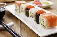 Sushi roll pieces served with soy sauce and a small plate of pickled ginger and wasabi.