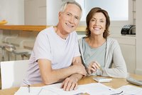 Senior couple going over bills with calculator