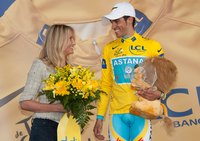 An athlete wearing a uniform with sponsor's logos receives flowers from a woman.