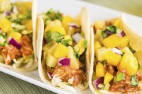 Finish tacos with cilantro and a squirt of lime.