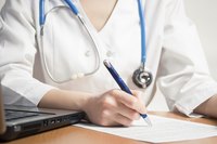Doctor writing a letter with a pen.