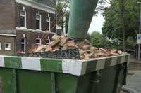 Construction debris filling a roll-off container at a construction site.