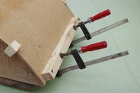 Wooden blocks add extra pressure to glued particleboard.