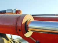 A close-up of a hydraulic cylinder outdoors.