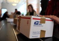 Customers wait in line to deliver packages at post office