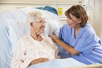 A hospice nurse talks to an elderly female patient