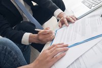 A close-up of a client signing documents with an agent.