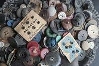 An overhead view of a ceramic dish filled with old buttons.