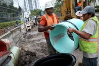 Construction workers building systems to combat rising sea levels.