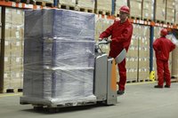 Workers at a warehouse preparing goods to be shipped.