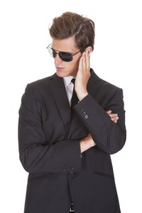 Sunglasses and a dark suit complete a secret agent or bodyguard costume.