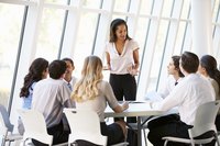 A female project manager addresses colleagues in a conference room