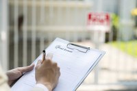 Close-up of contract being filled out on clipboard