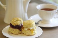Scones served with fruit jams and hot tea.