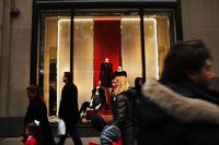 Shoppers walking past a store window display in the city.