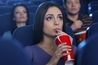 Woman drinking soda in movie theater