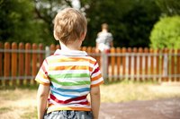 The back of a little boy standing in a playground.